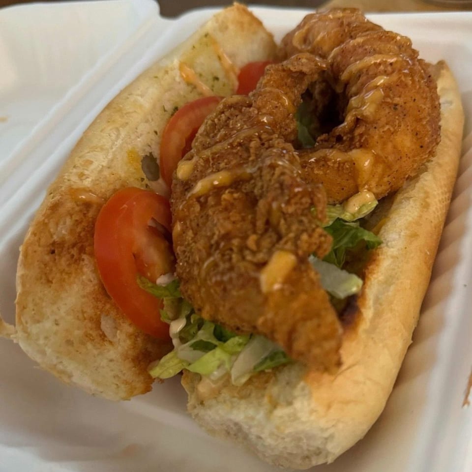 Deja Soul's fried shrimp po'boy with lettuce, tomato, and sauce on a hoagie roll.