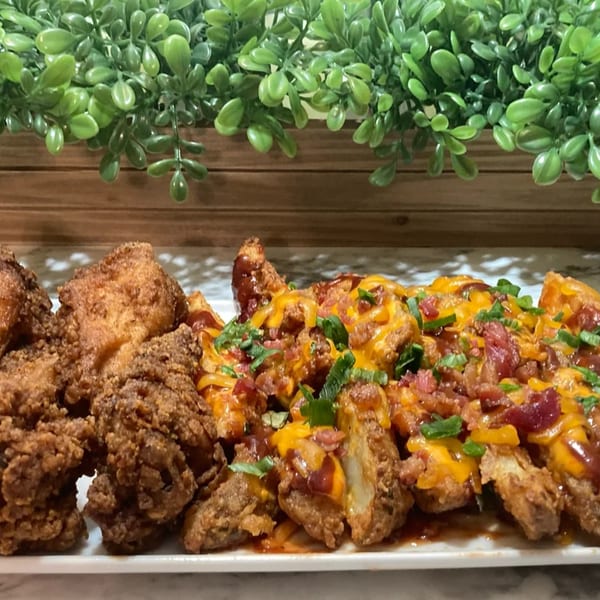 Crispy fried chicken and loaded potato wedges with cheese, bacon, and green onions.